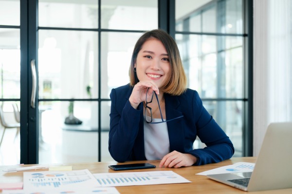 Woman smiling at desk with papers in front of her